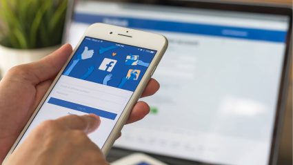 Person using mobile phone with Facebook app open