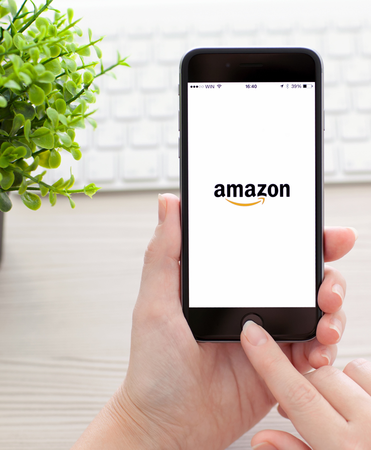 person holding phone with amazon logo