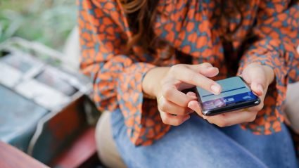 Closeup of woman using Facebook app on mobile phone