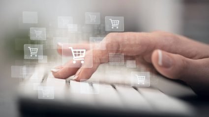Person typing on keyboard beneath ecommerce concept graphics