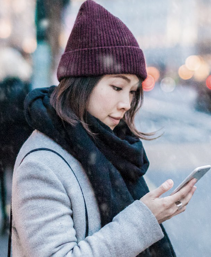 Woman outside in winter looking at phone