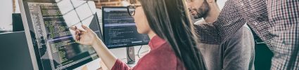 woman looking at computer screen with code on it