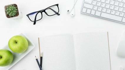 Desk with computer, plant and apples