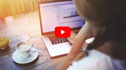 woman on computer looking at analytics youtube play button