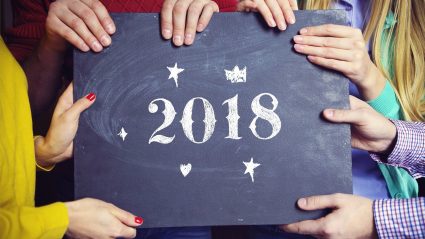Hands holding chalkboard sign with 2018