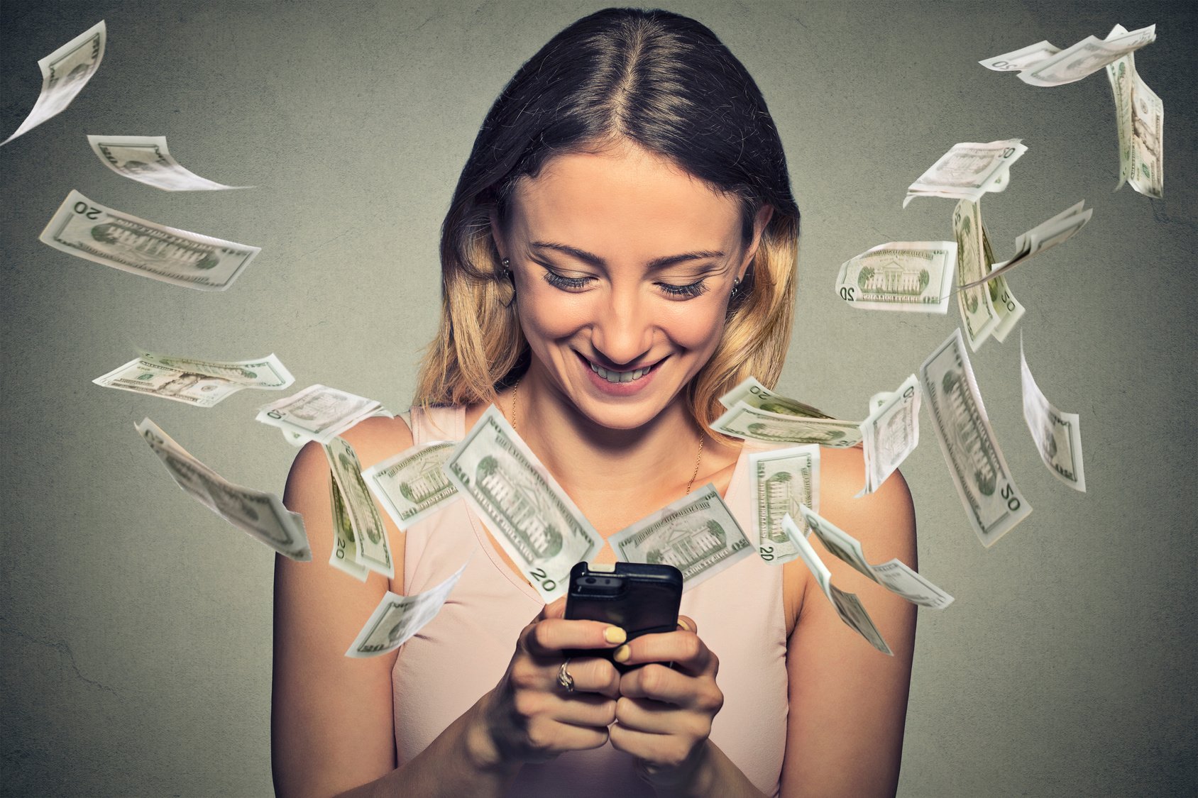 Money flying out of phone held by a smiling woman