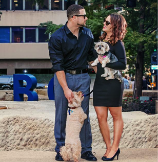 Couple standing next to Poodle/Bichon Frise