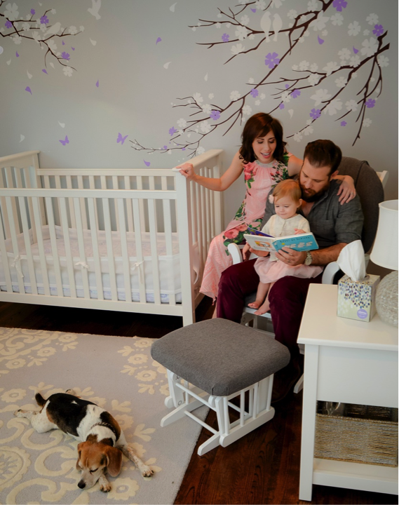 block and family reading to baby in nursery while bixby lays by feet