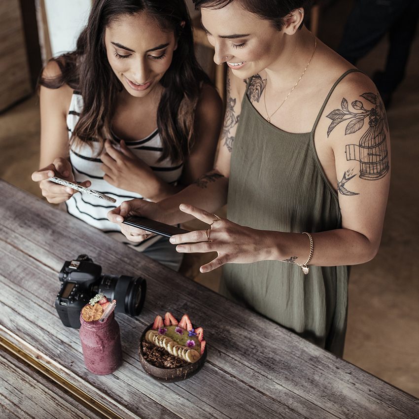 Two woman taking a photo of food