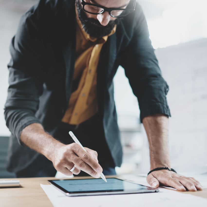 Man working on desk with tablet
