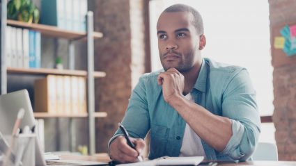 man sitting at desk with laptop making a decision