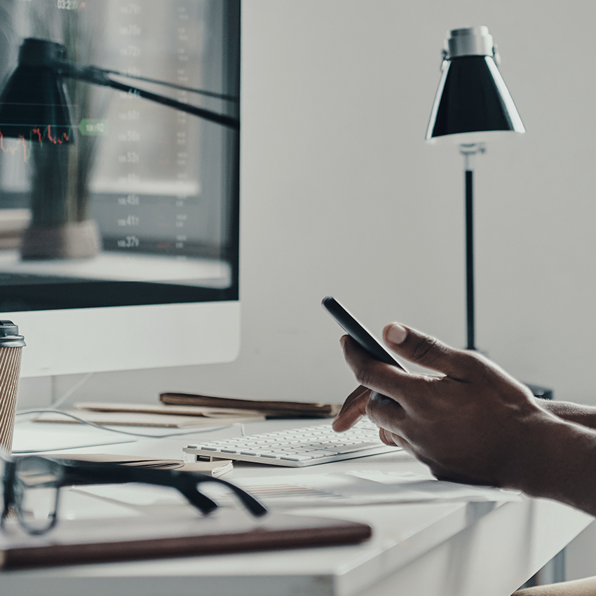 man holding phone at desk