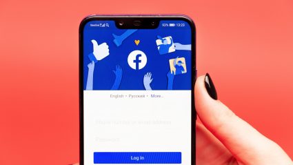 Facebook login screen on phone on coral colored background