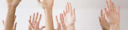 group of raised hands on light grey background