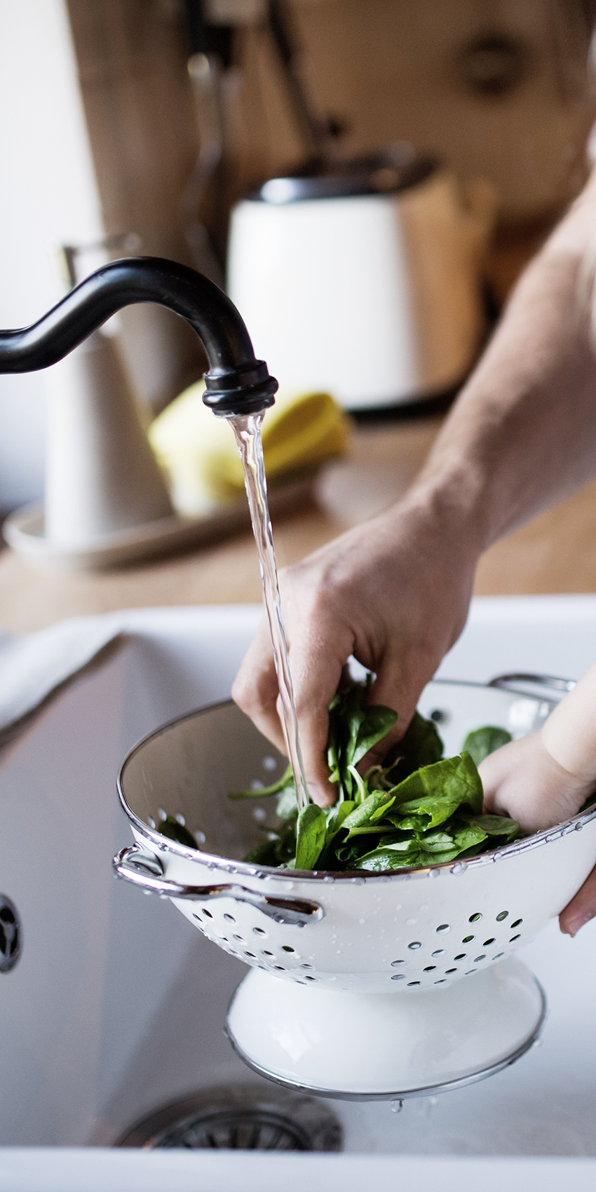 father and son washing spinach in sink