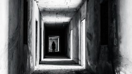 Figure standing in the background of long dark corridor