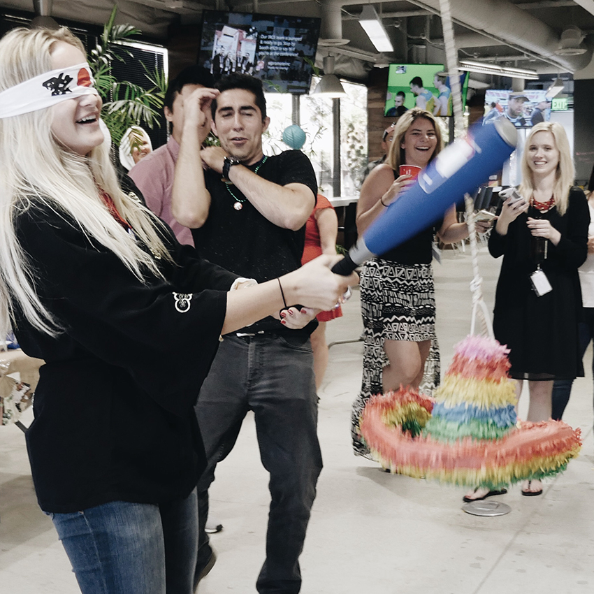 Wpromote team hitting a piñata