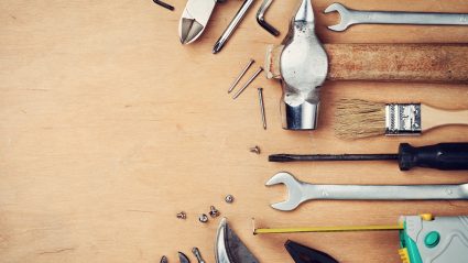 collection of tools laid out on wood surface