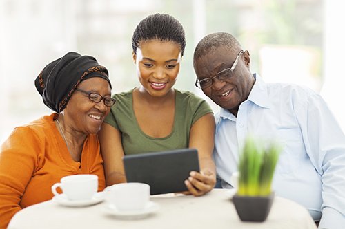 young woman with older parents all looking at ipad