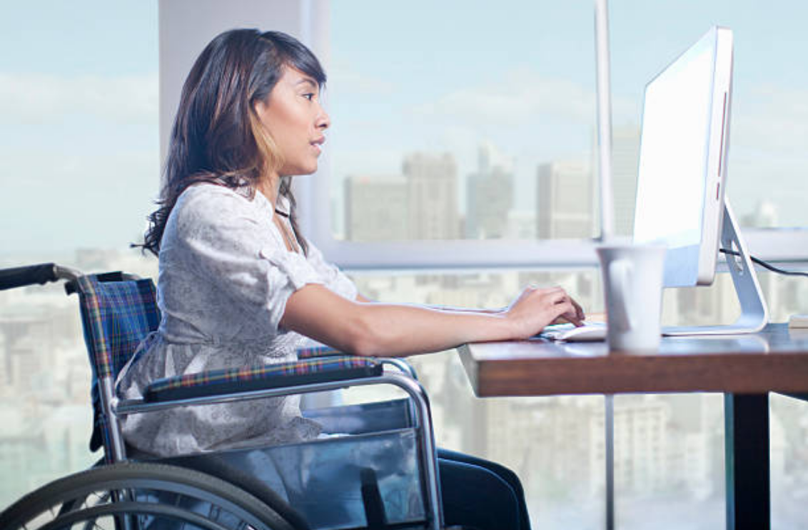 woman in wheelchair typing on computer
