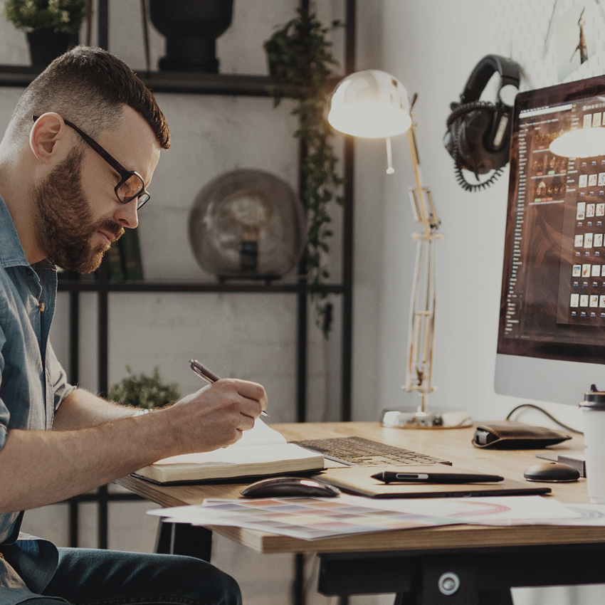 man working on desktop computer in home office