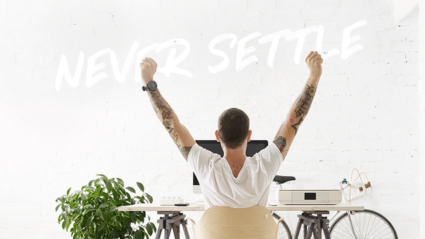 Man at desk with arm raised