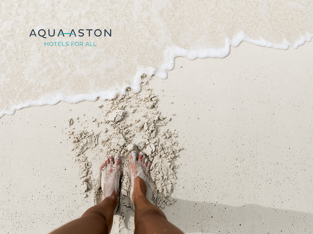 feet at shore of a white sandy beach