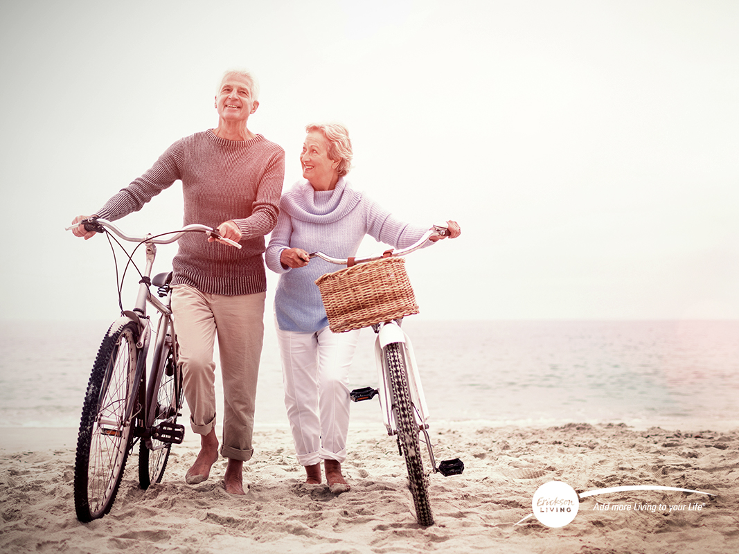 senior couple with bikes on beach