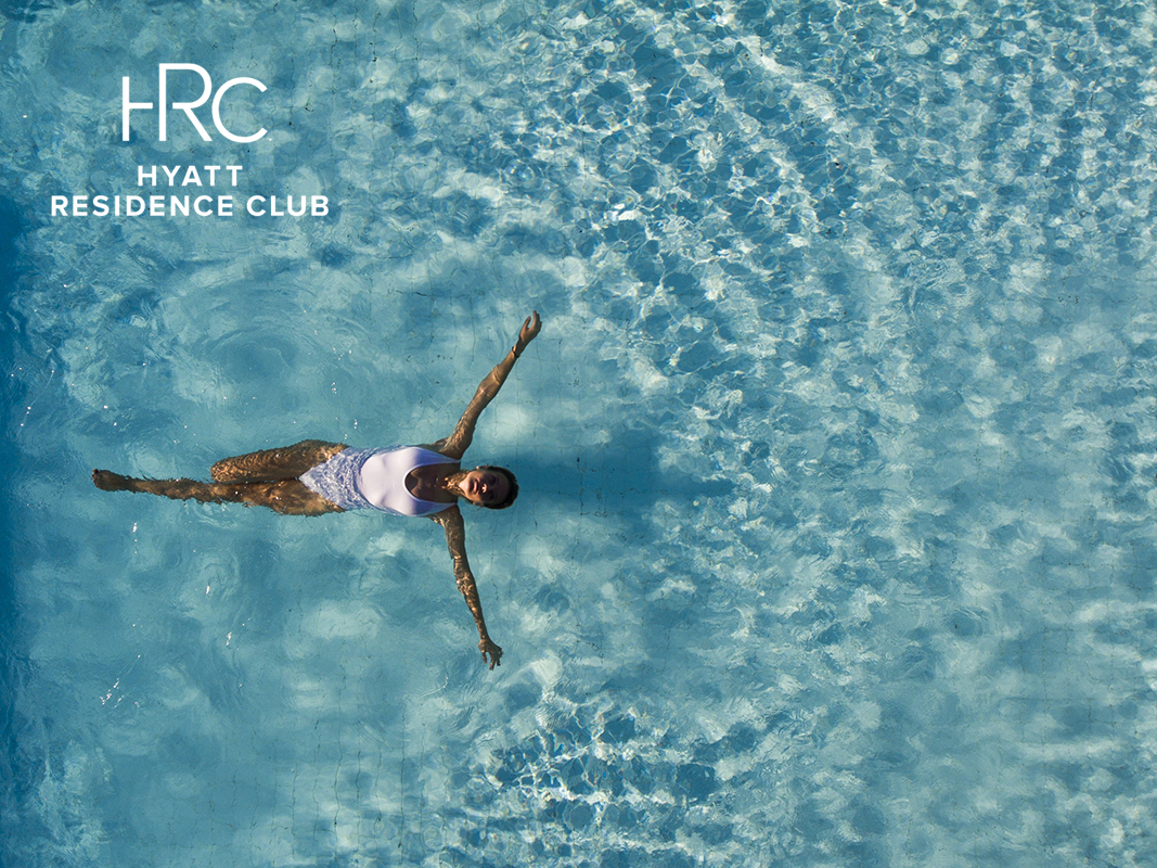 aerial shot of woman swimming in resort pool