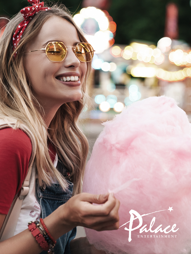 young woman eating cotton candy at theme park
