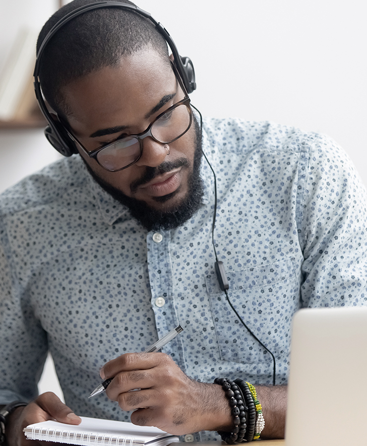 Man watching webinar taking notes