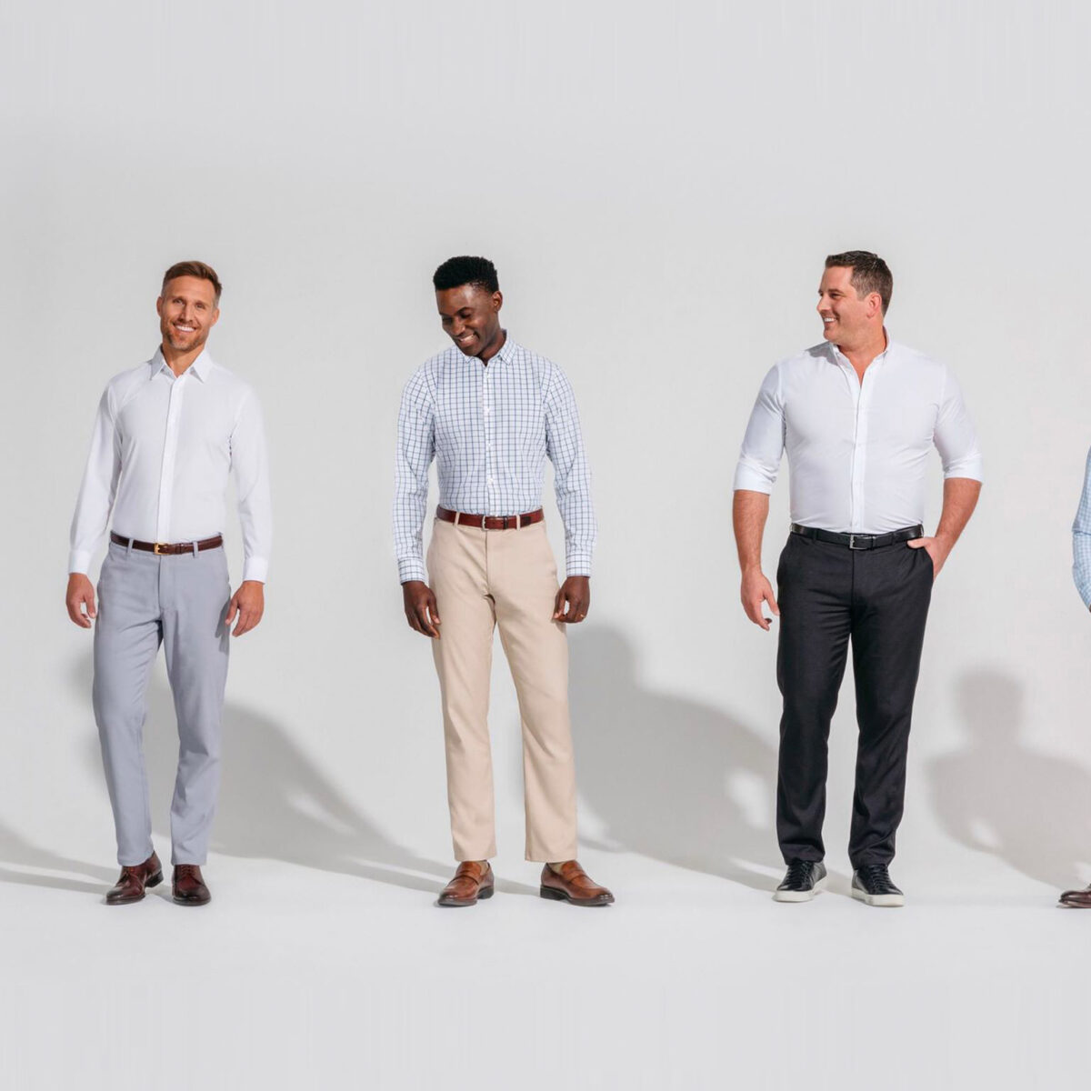 Five men stand side by side against a plain background, wearing business casual outfits including dress shirts, slacks, and dress shoes.
