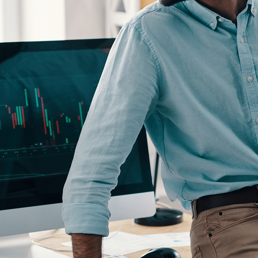 man leaning against desk with data on screen