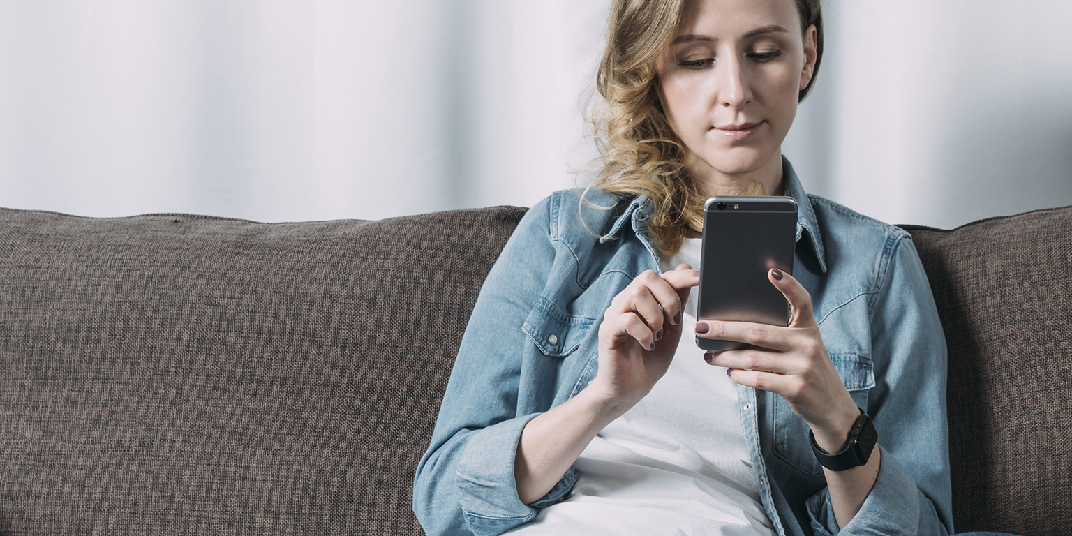 Woman looking at phone on couch