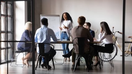 Group of six marketing professionals meeting in a modern office space