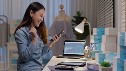 Small business order looking at her phone as she fulfills online orders