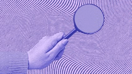 Hand with magnifying glass on purple background