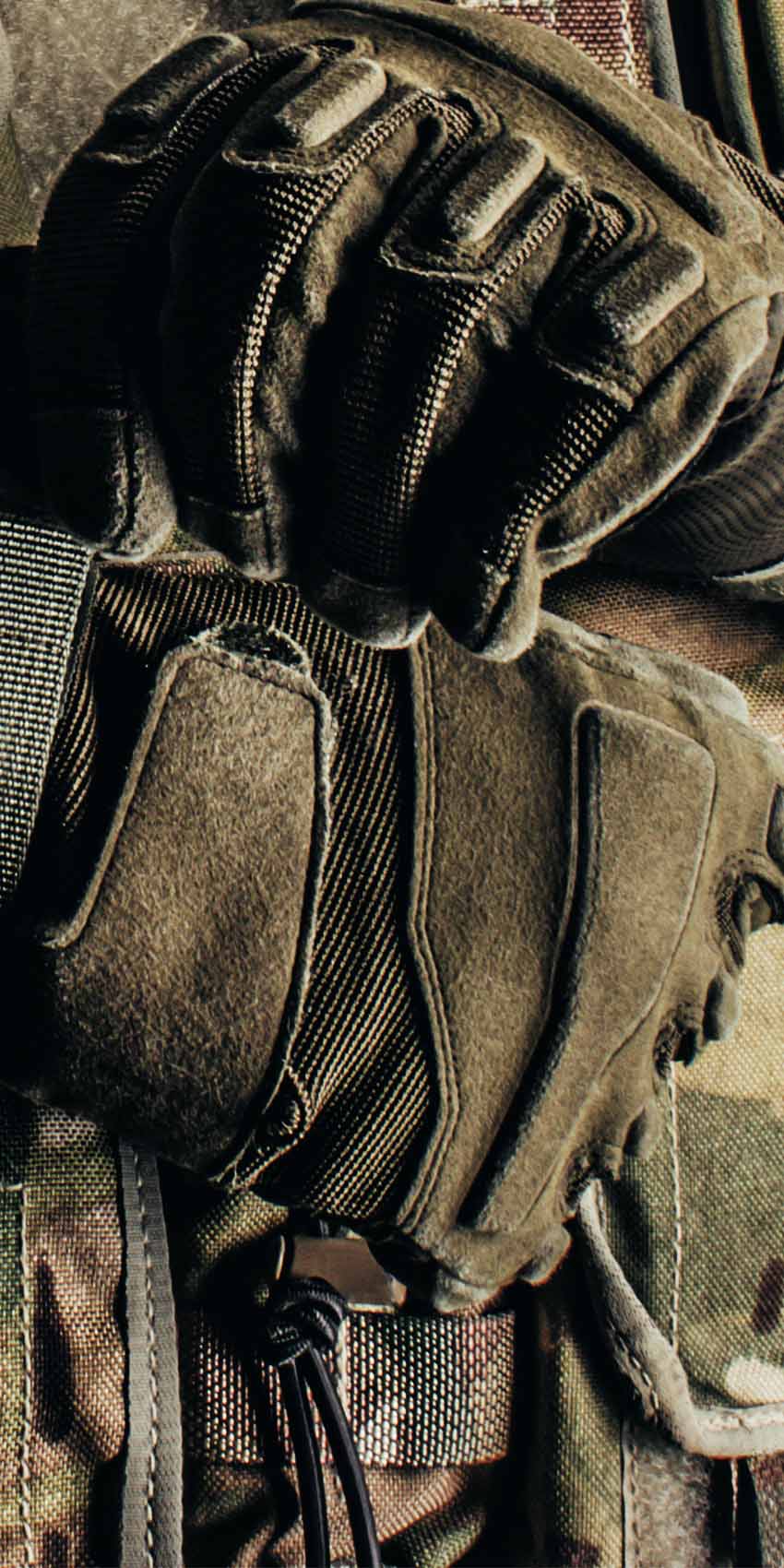 Soldier in camouflage strapping on gloves