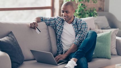 Man with credit card looking at computer