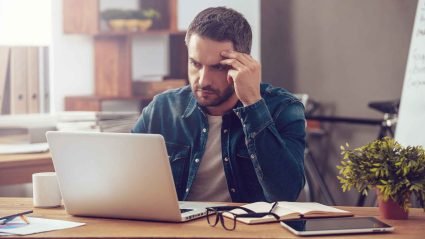 Man looking confused while working on computer