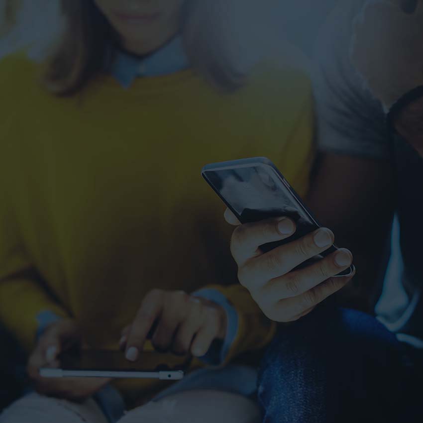 A person using a tablet and another person using a mobile phone