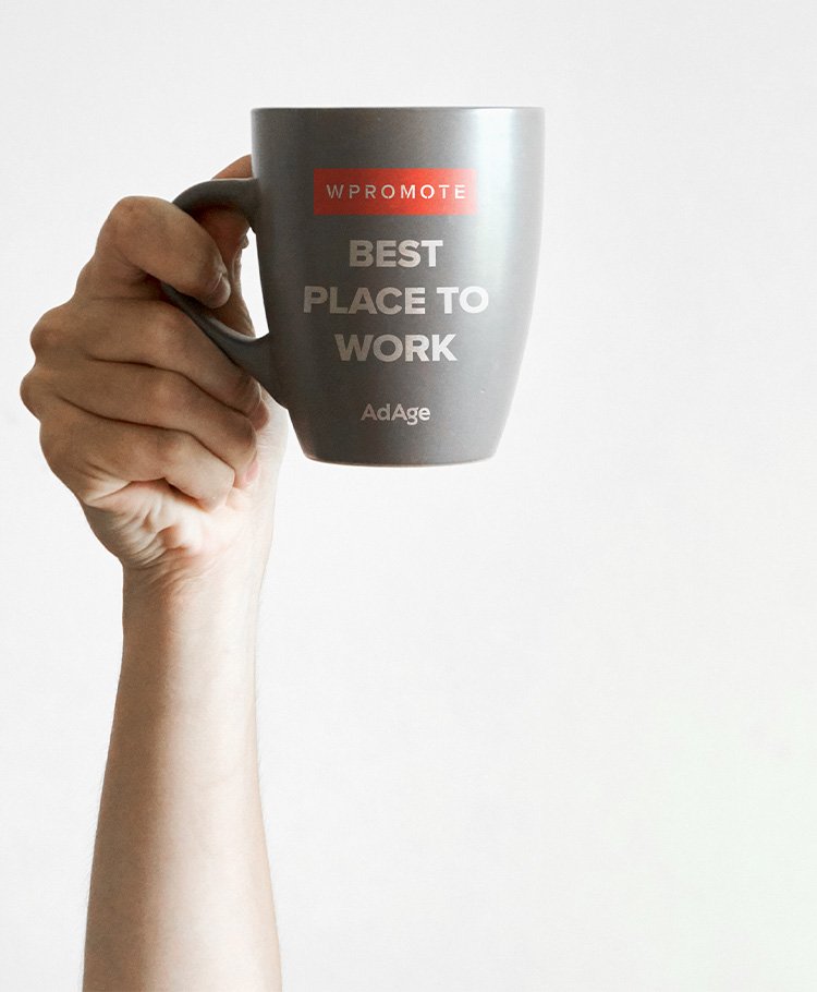 Hand holding a mug that reads: 