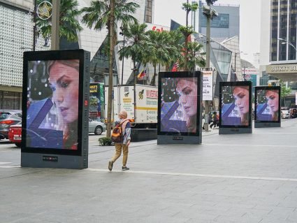 Digital billboards showing an ad on a street