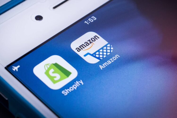 A smartphone screen displays the Shopify and Amazon app icons side by side.