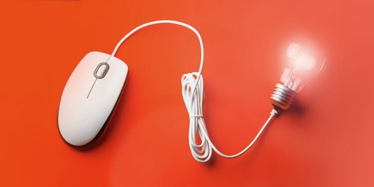 A white computer mouse with its cord shaped like a lightbulb that is glowing, set against a bright orange background.