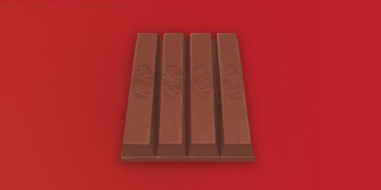 A four-finger milk chocolate KitKat bar is centered on a red background.