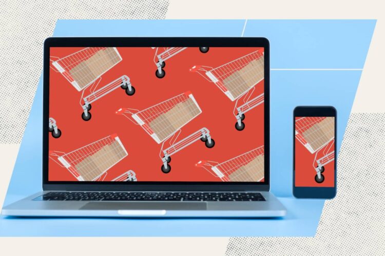 A laptop and smartphone display a repeating pattern of shopping carts on a red background, placed on a light blue and beige surface.