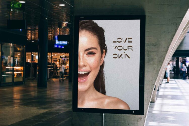 A digital poster in a modern indoor space shows a smiling woman next to the words "LOVE YOUR SKIN" in bold letters.