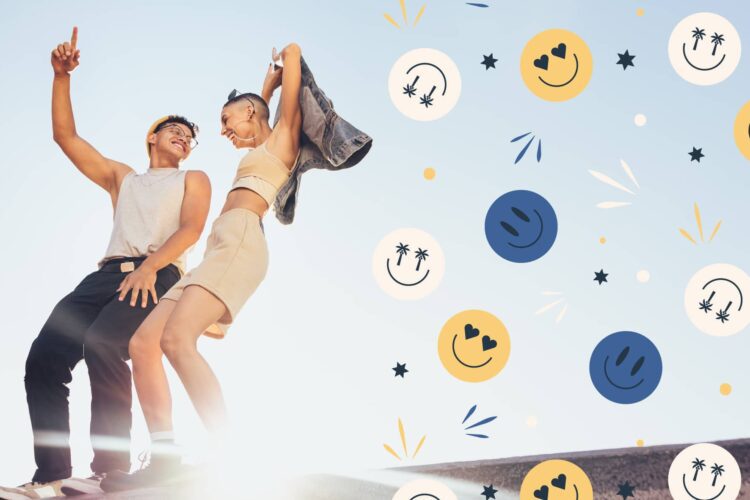 Two people stand outdoors smiling and posing in casual summer clothes with colorful smiley face graphics on the right side of the image against a clear sky.