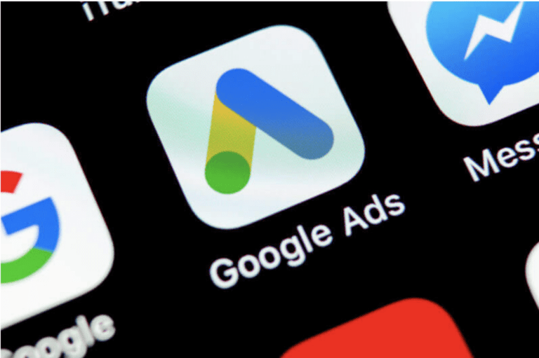 Close-up of the Google Ads app icon displayed on a smartphone screen, with part of other app icons visible around it.